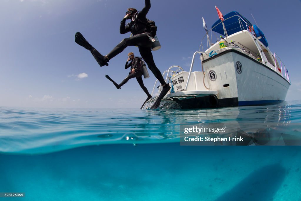 Giant stride entry into calm ocean.