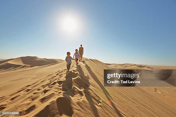 family walking up a sand dune - walvis bay stock pictures, royalty-free photos & images