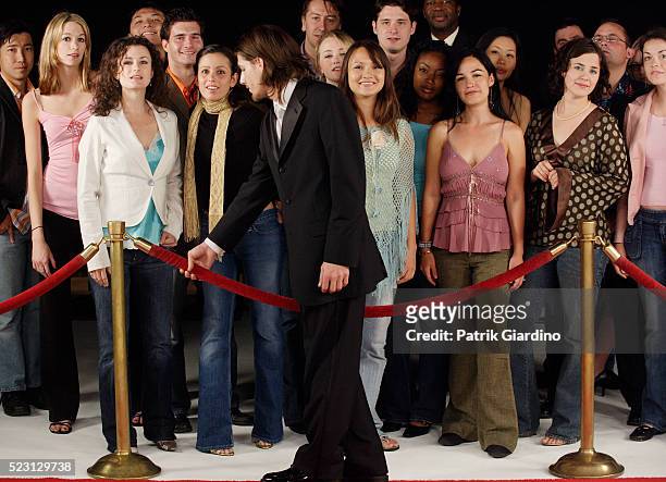 crowd waiting behind velvet rope - film premiere stock pictures, royalty-free photos & images