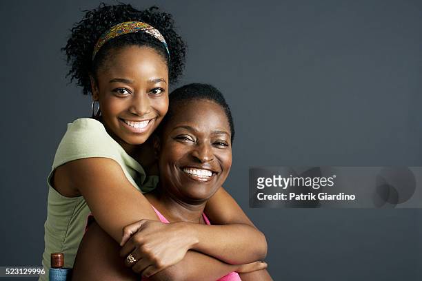 mother and daughter hugging - formeel portret stockfoto's en -beelden