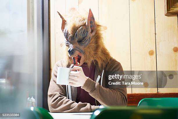 werewolf with mug in cafe - werewolf stock-fotos und bilder