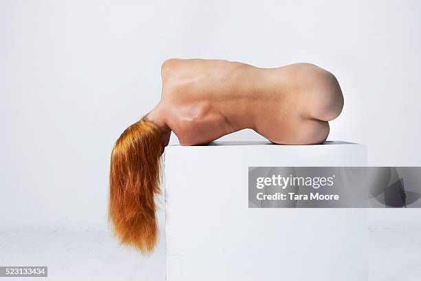 studio shot of red-haired female laying down on side and bending, nude back view against white background - lying on back ストックフォトと画像