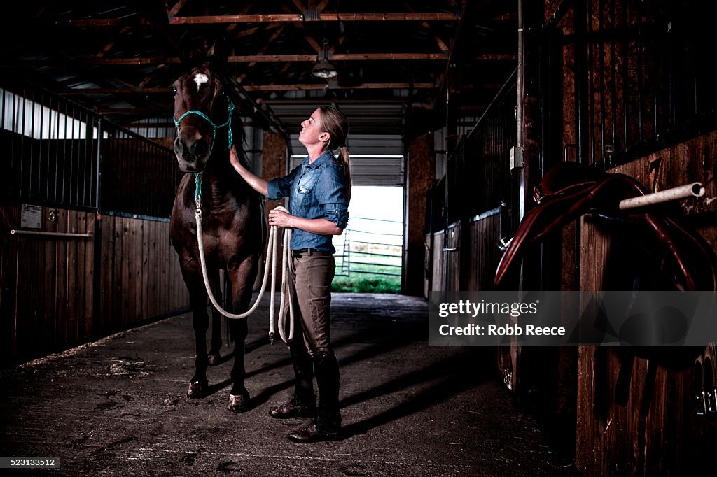 Woman with horse in stables