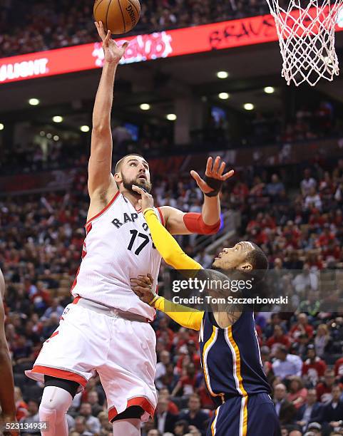 Jonas Valanciunas of the Toronto Raptors shoots as Monta Ellis of the Indiana Pacers tries to defend in Game One of the Eastern Conference...