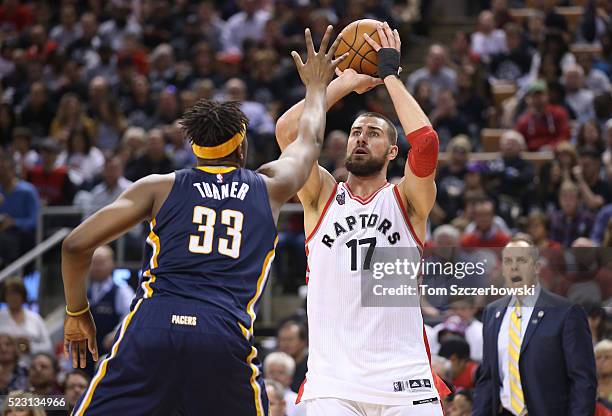 Jonas Valanciunas of the Toronto Raptors controls the ball as Myles Turner of the Indiana Pacers defends while head coach Frank Vogel watches in Game...