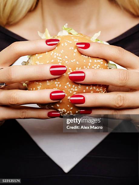 young woman holding burger - hamburger stock pictures, royalty-free photos & images