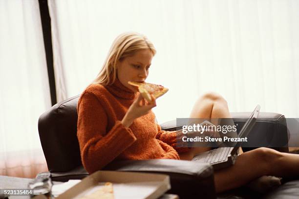 woman with laptop eating pizza - overworked computer stock pictures, royalty-free photos & images