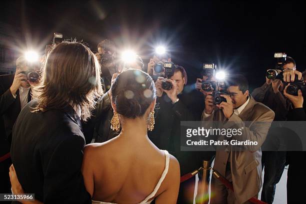 celebrity couple posing for paparazzi - red carpet event stock-fotos und bilder