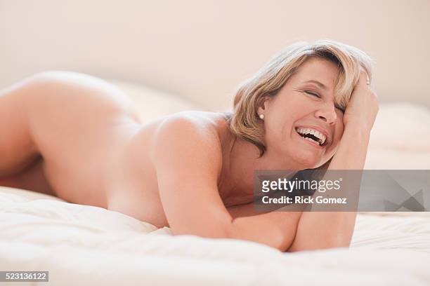 middle-aged woman lying in bed - nu imagens e fotografias de stock