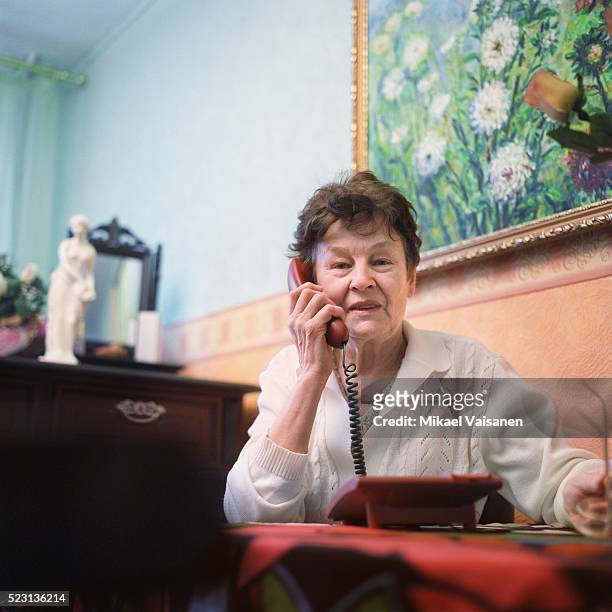 senior woman using telephone - telefonhörer stock-fotos und bilder