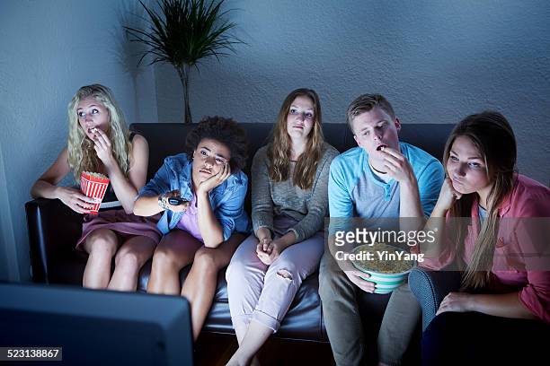 young adult group bored by tv programing - bored audience stock pictures, royalty-free photos & images