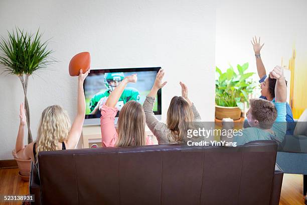 groupe de jeunes en regardant le sport à la télévision ensemble du programme de football - football américain femme photos et images de collection