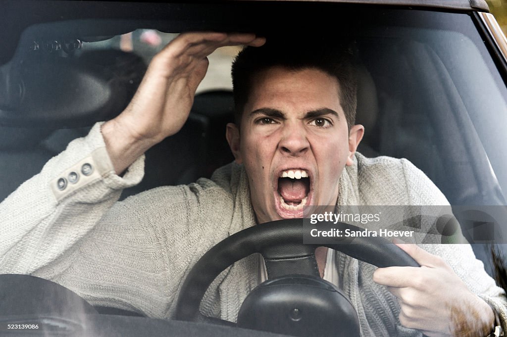 Young man gets angry while driving the car