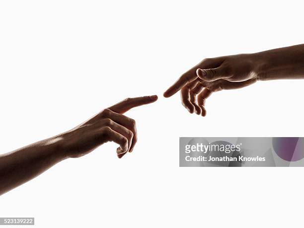 studio shot of two human hands, touching fingers, white background - touching photos et images de collection