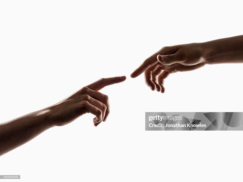 Studio shot of two human hands, touching fingers, white background