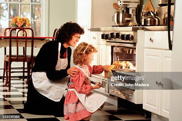 mother teaching daughter how to bake muffins - madre ama de casa fotografías e imágenes de stock