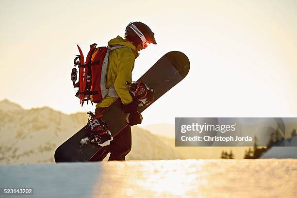 young male snowboarder walking through snow, tyrol, austria - snow board stock pictures, royalty-free photos & images