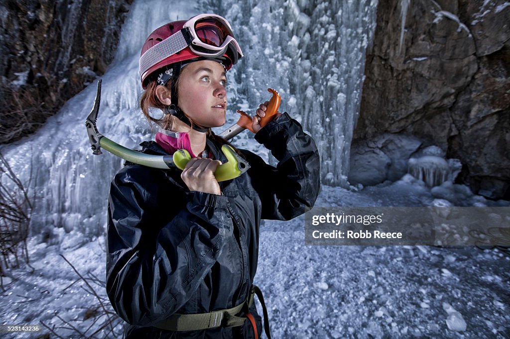 Young female ice climber with ice tools