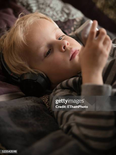 7-year old boy listening to his ipod - boy ipod bildbanksfoton och bilder