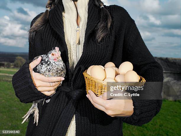 young woman holding chicken and basket with eggs - eggs basket stock pictures, royalty-free photos & images