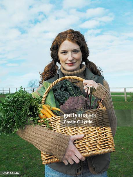 young woman with basket of vegetables - agritoerisme stockfoto's en -beelden