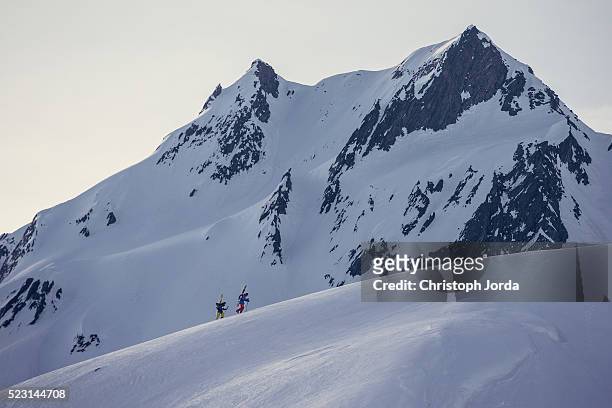 ski tourers hiking up a mountain - andermatt stock pictures, royalty-free photos & images