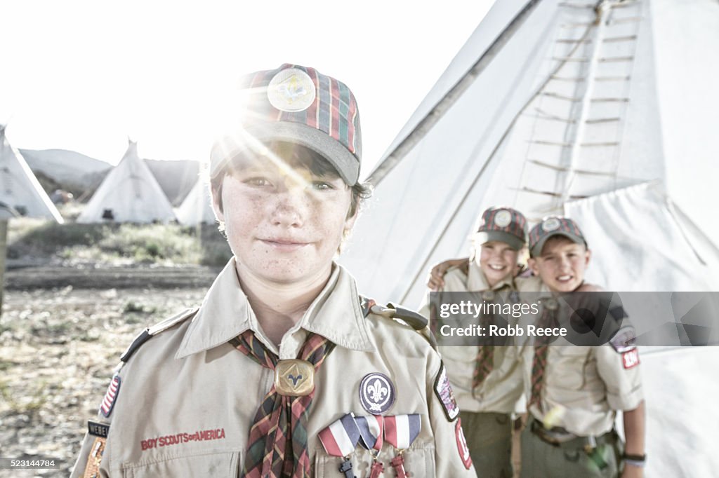 Three young, Weblo Boy Scouts standing near a teepee at a camp in Colorado.