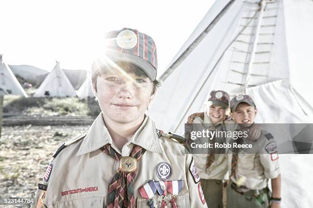 three young, weblo boy scouts standing near a teepee at a camp in colorado. - boy scout camping stockfoto's en -beelden