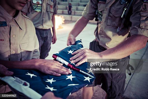 boy scouts fold an american flag during a ceremony at their camp in colorado. - boy scout camp stockfoto's en -beelden