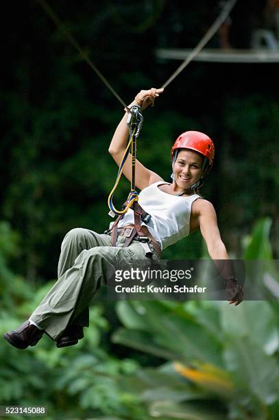 smiling woman hanging on zip line - costa rica zipline stock pictures, royalty-free photos & images