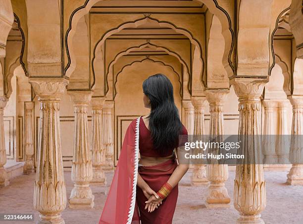 woman standing amid columns - hugh sitton india stockfoto's en -beelden