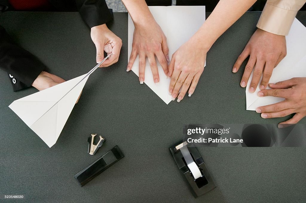 Co-workers Folding Paper Airplanes
