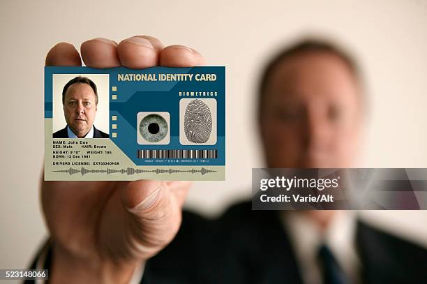 man holding identity card - carta d'identità foto e immagini stock