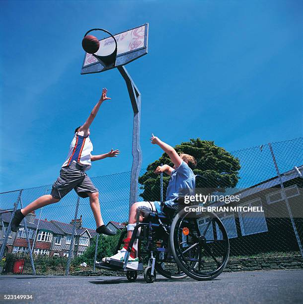 disabled teenage boy in a wheelchair playing basketball, spinal cord injury, paraplegic - paraplégico imagens e fotografias de stock