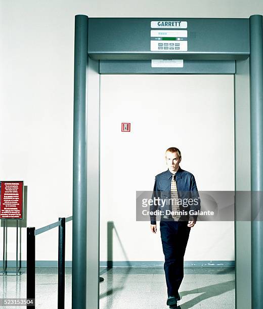 traveler approaching metal detector - airport security stock pictures, royalty-free photos & images