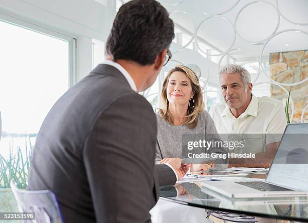 couple talking to financial advisor - finanzplanung stock-fotos und bilder