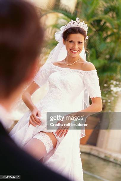 bride revealing garter belt for bridegroom - vintage garter belt stockfoto's en -beelden