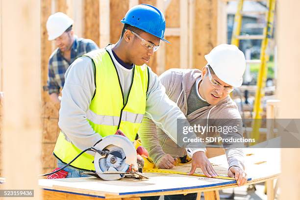 men work together at construction site - hispanic construction worker stock pictures, royalty-free photos & images