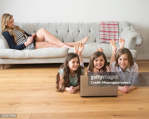 mum relaxing, children on the computer - barefoot girl stock pictures, royalty-free photos & images