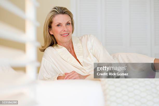 middle-aged woman lying in bed - nightdress stock pictures, royalty-free photos & images