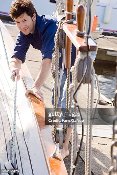 man docking sailboat - anchored boats stock pictures, royalty-free photos & images