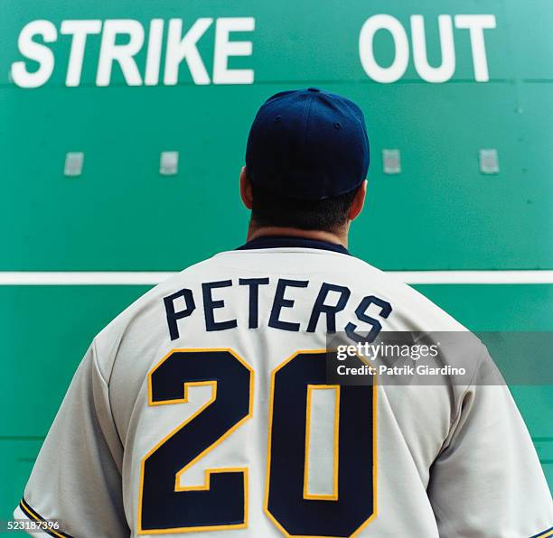 baseball player staring at scoreboard - honkbaltenue stockfoto's en -beelden