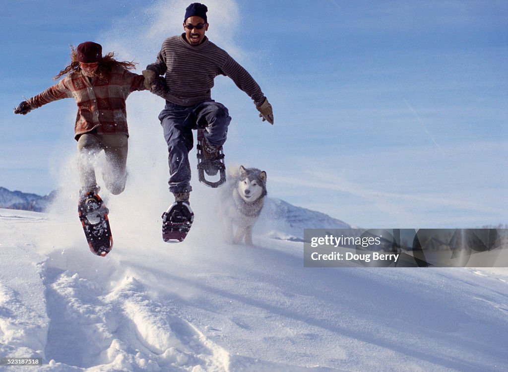 Couple Leaping in Snowshoes