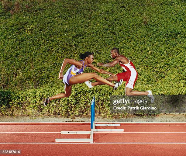 hurdlers jumping in opposite directions - hurdling track event fotografías e imágenes de stock