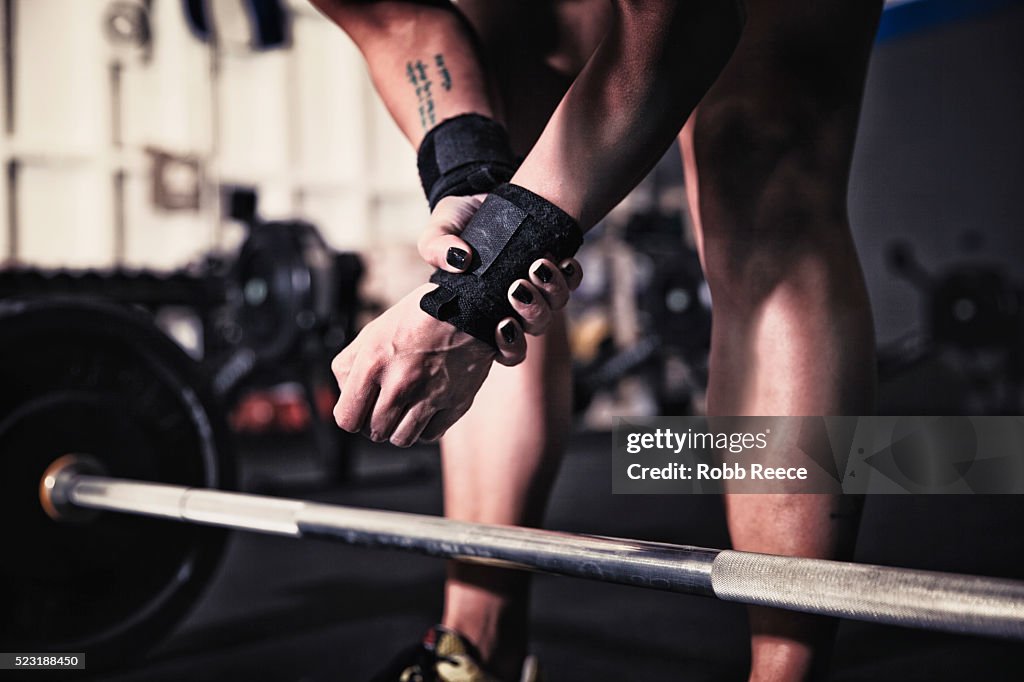 Woman preparing to lift weights in gym gym