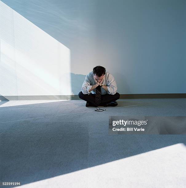 businessman sitting in empty room - werkloos stockfoto's en -beelden