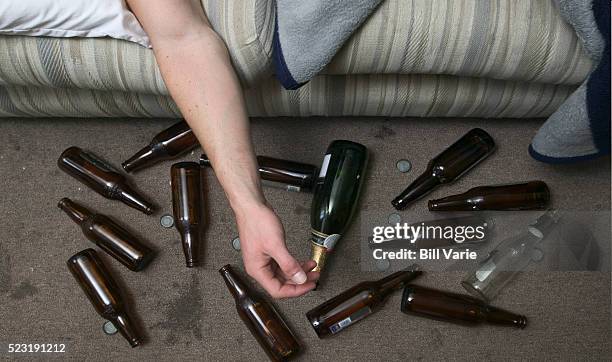 drunk man and beer bottles - alcoholisme stockfoto's en -beelden