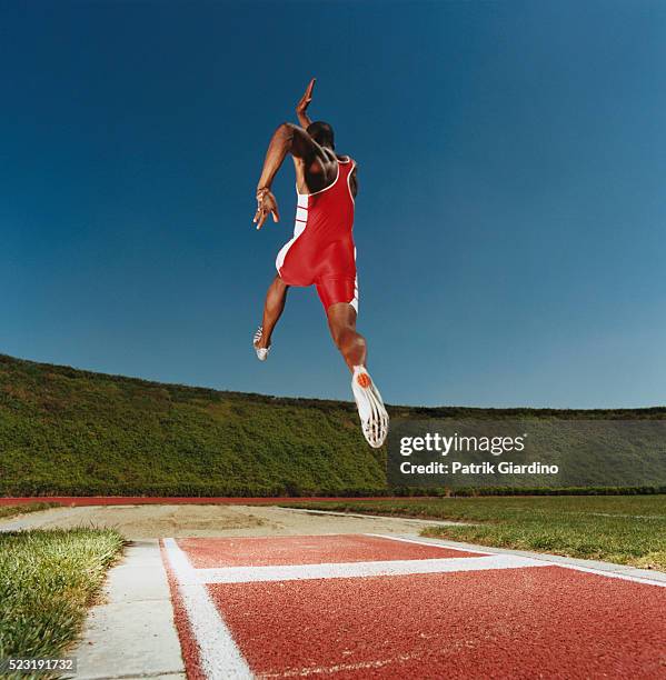 long jumper in midair - verspringen stockfoto's en -beelden