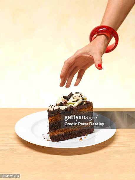 woman reaching for a slice of cake - taartpunt stockfoto's en -beelden