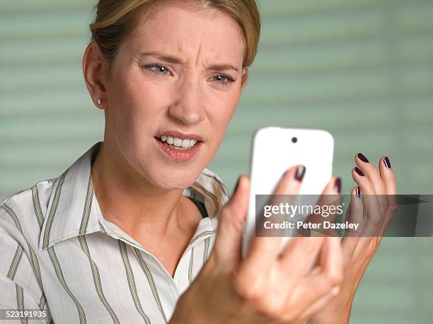 unhappy woman on smart phone - angry on phone photos et images de collection